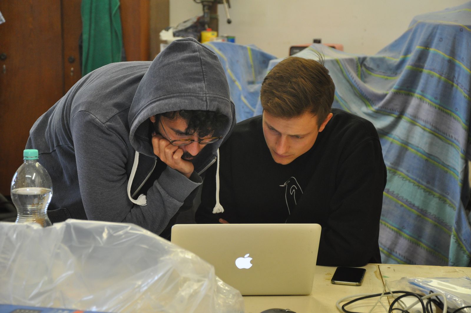 Roman Alberti und Afshin Doostdar in der Anfangszeit von Voltfang an einem Laptop in einer Werkstatt