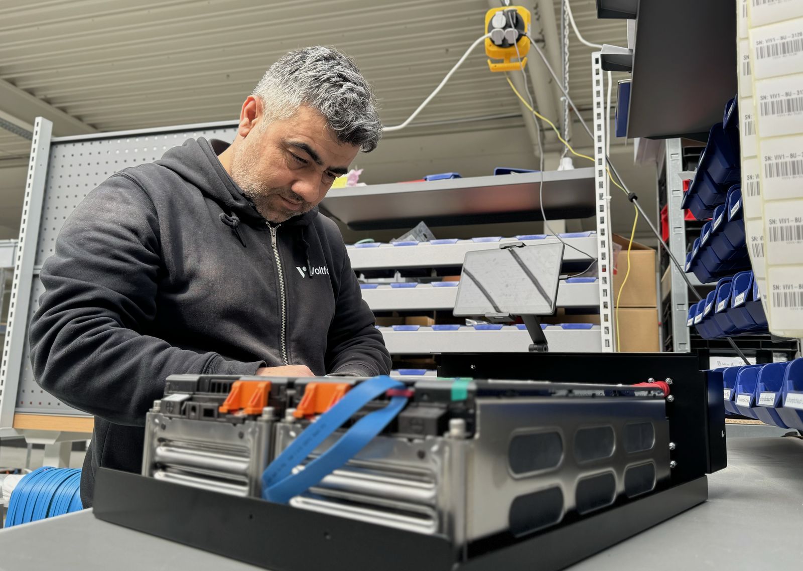 Mitarbeiter montiert ein Batteriemodul in der Voltfang-Fertigung